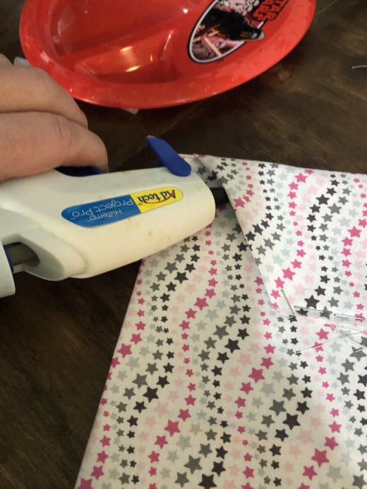 Add a row of hot glue under any visible corners of the fabric.