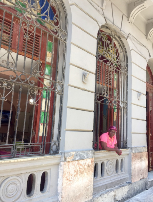 A woman waiting for clients to her small establishment where she serves food.