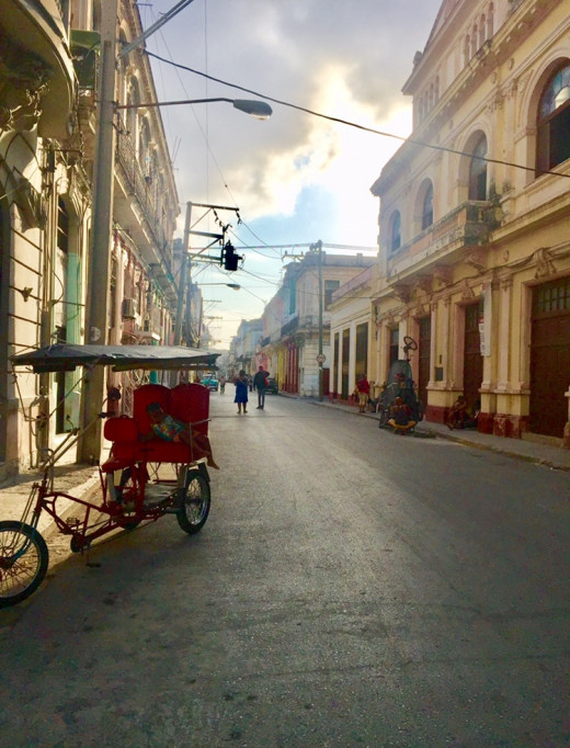 After heavy rainfall. A small child is resting under the roof of a bicycle taxi in Centro Havana.