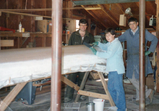 Draping the fiberglass cloth over the canoe.