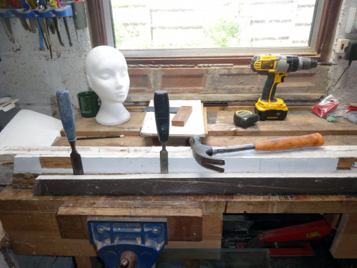 Using old chisels and hammer to prise off the door stop from the doorframe.