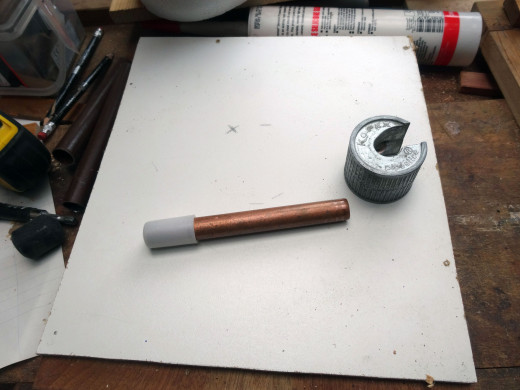Copper pipe to be used to support one of the polystyrene heads cut to length with a pipe cutter.