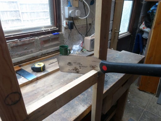 Using a Japanese saw to carefully remove the old middle rail.