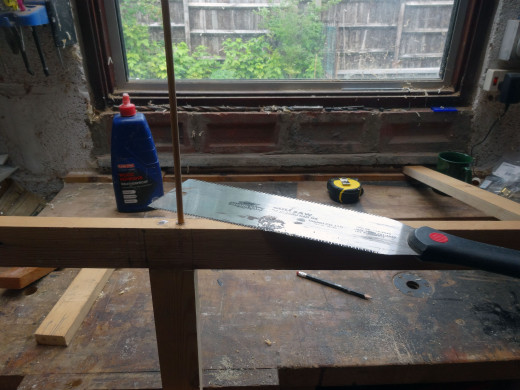 After gluing the dowels in place, cutting the dowel flush with the wood with a Japanese saw.