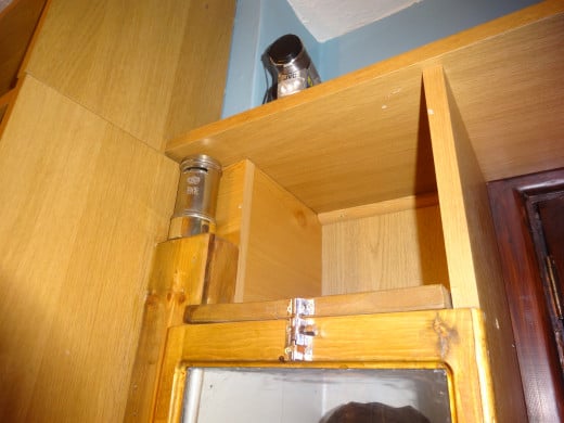 The bolt fitted to the top to secure the front panel in place, and above (on the left) the nook created, during the conversion from shelving to display cabinet, and left as a design feature for storing and displaying my son’s silver plated money box.
