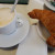 A cup of cappuccino and a croissant is a perfect breakfast in the morning. 