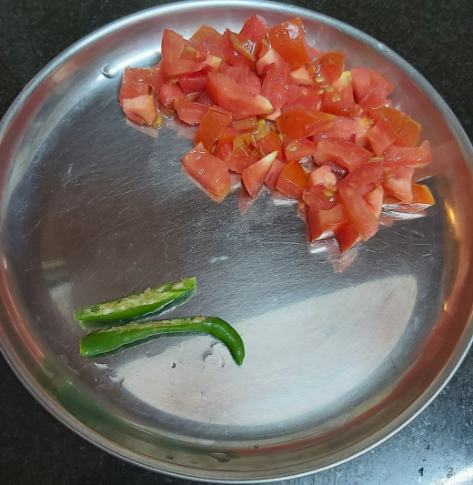 Wash and chop 1-2 ripe tomatoes, split or chop 1-2 green chilies and keep aside.