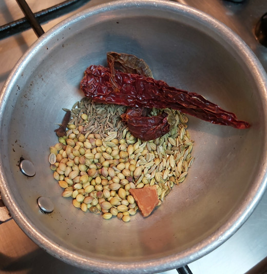 In a frying pan, dry roast 1 teaspoon of cumin seeds, 1 teaspoon coriander seeds, 1/2 teaspoon fennel seeds or saunf, 1-2 cinnamon, 1-2 cloves and 1-2 red chilies.