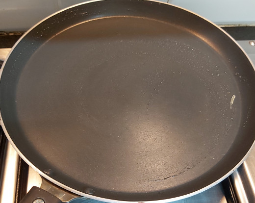 Heat tawa or pan on high flame. Smear some drops of oil and wipe off using cloth.