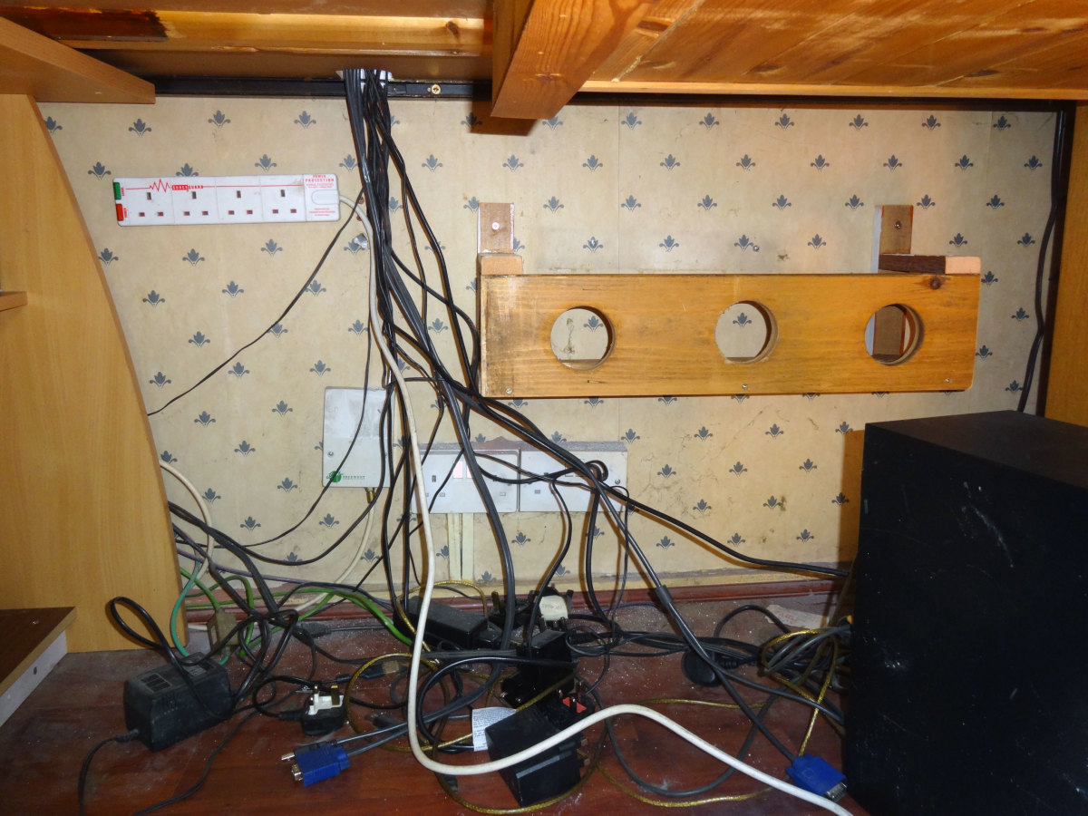 The cable management trough screwed to the wall, and a new 4-gang power surge socket also wall mounted under the desk 