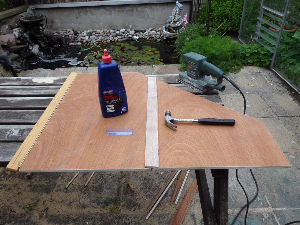 Using a strip of 4mm plywood to make a decorative cover for the piano hinge joining the two door segments