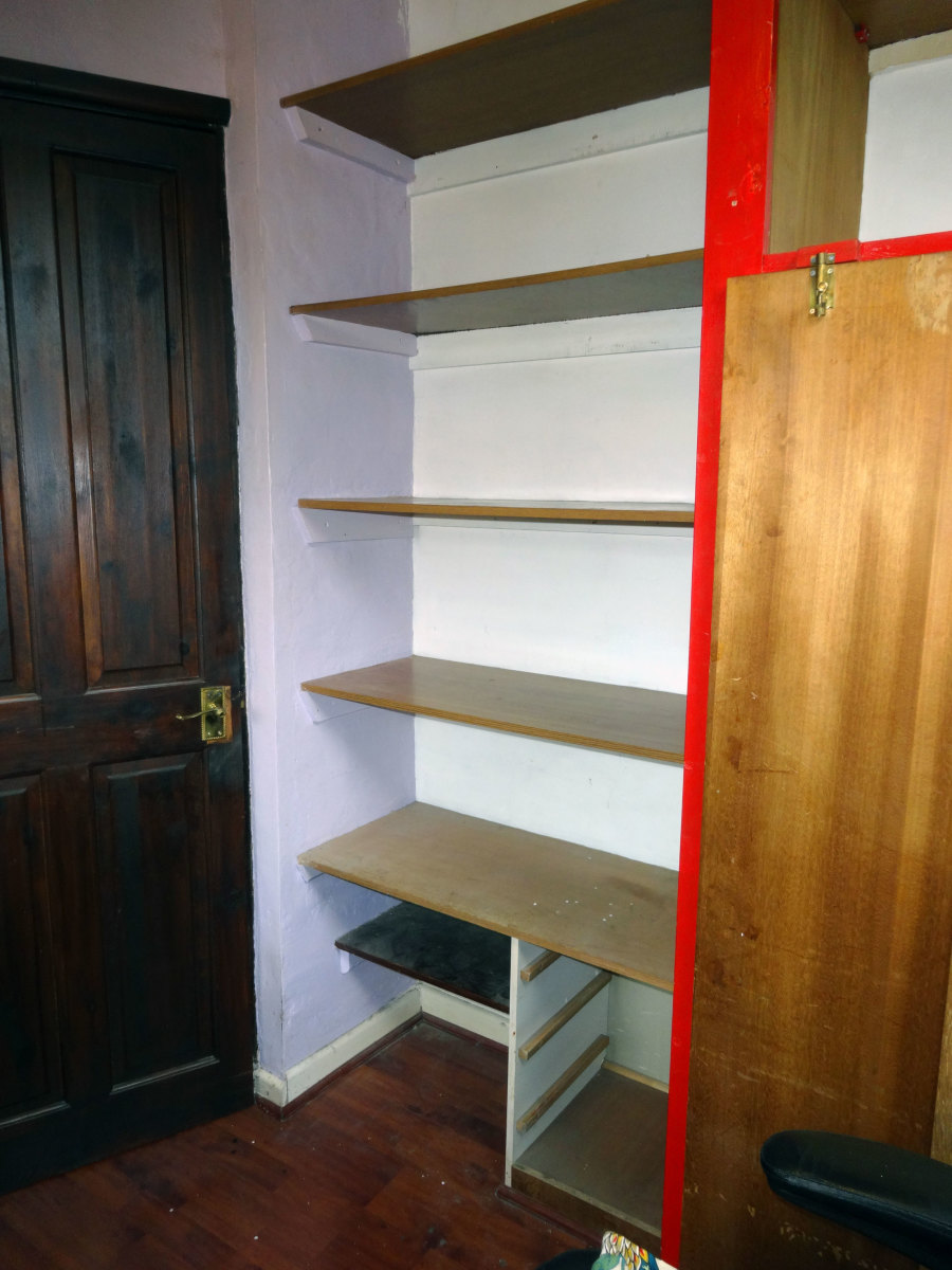 The old veneered chipboard shelving emptied, ready for dismantling and replacing