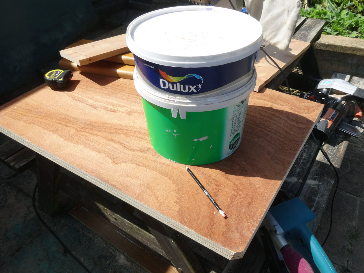 Using a large paint pot to mark out the curve for the inner corner of the unit