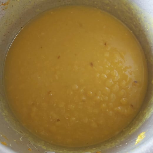 Using masher, hand blender or back of the ladle mash the dal properly till it turns smooth and mushy.