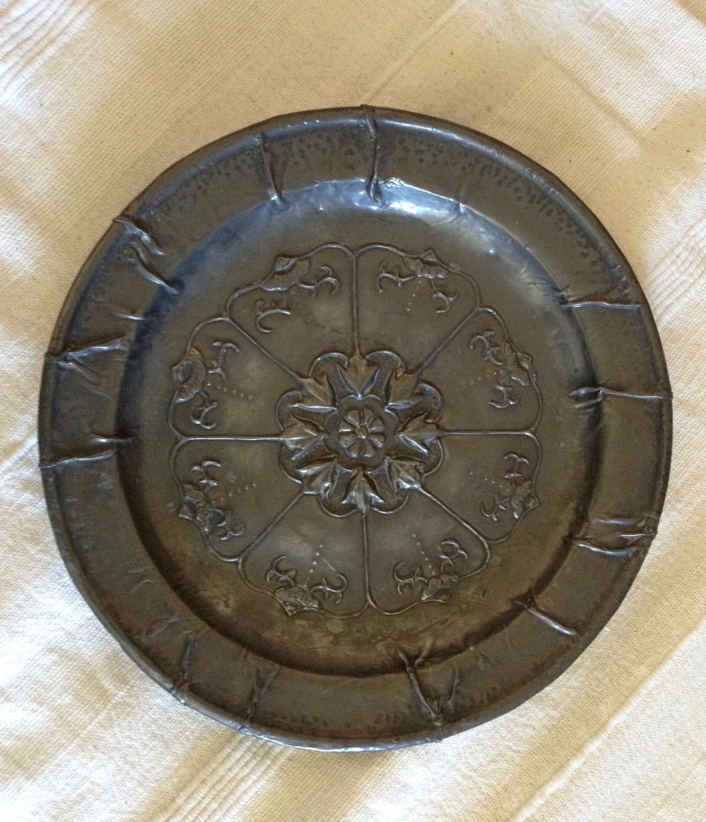 Plate, designed and stretched over a base.