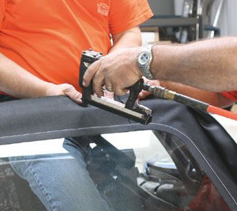stapling the new rear window curtain onto the rear top bow requires to people. Once fastened, the lower ends are stapled.