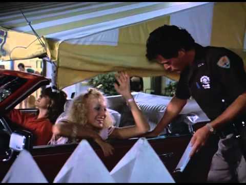 Sandra (Wendy Schaal L) and Laurie (Lynn-Holly Johnson) get pulled over by Officer Ernie Grasso (Asher Brauner) on their first night in Fort Lauderdale