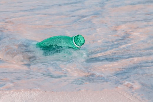 A plastic water bottle washes up on shore. Seeing trash on the beach reminds us of the garbage patches that unforgivingly float over our oceans, and the dire need for us to step up efforts in transitioning to a world free from single-use plastics.