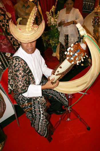 A man wearing Tiilangga (traditional hat) with Sasando beritadaerah.com