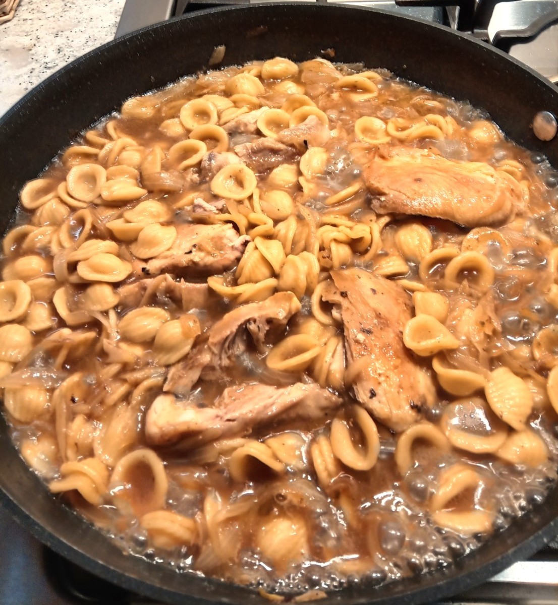 Pasta is cooked and the chicken is nestled back into the pan, ready to serve