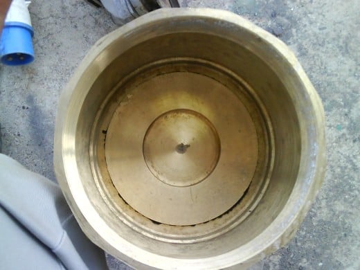 Inside view of foot valve: plate rests on the seat of valve due to force exerted by spring