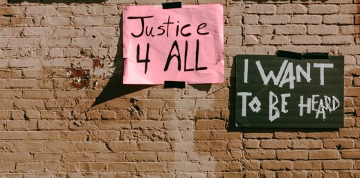 "Justice 4 all" and "I want to be heard" banners duct taped on a brown brick wall - Photo by RDNE Stock project on Pexels
