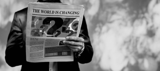 A man holding a newspaper on the back of which an article with the title "The world is changing" can be observed - Image by Gerd Altmann from Pixabay
