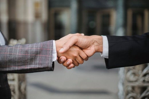 Two people in a suit shaking hands. A sign of a future political coalition - Photo by Ketut Subiyanto