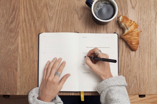 Person writing a book, photo by Cathryn Lavery on Unsplash