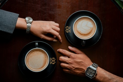 A couple of people sitting at a table with cups of coffee, photo by Circle Digital Marketing Agency