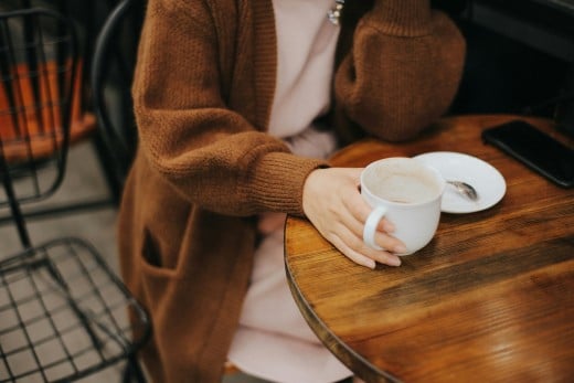 Woman sitting on chair while holding white mug, photo by Alphacolor on Unsplash
