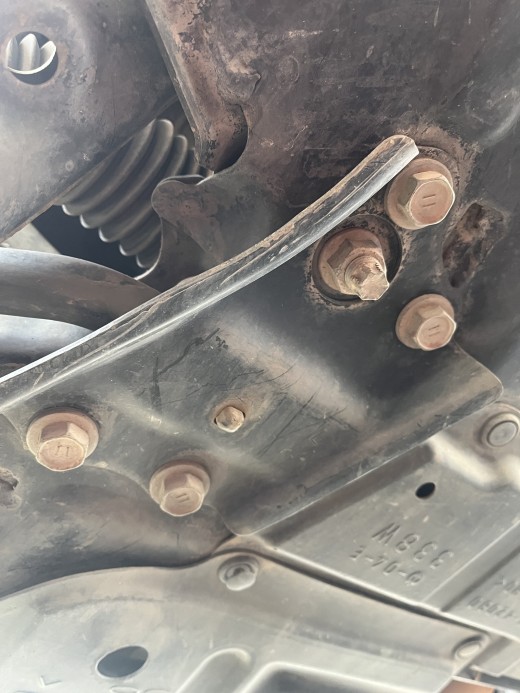Sway bar bushing cover plate from underneath the vehicle. Note the location of the protruding rubber nipple in the center.