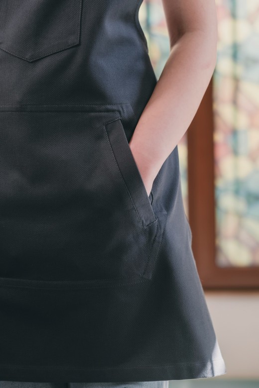 A woman wearing a black apron with a pocket, photo by Golden Horn Bridge on Unsplash