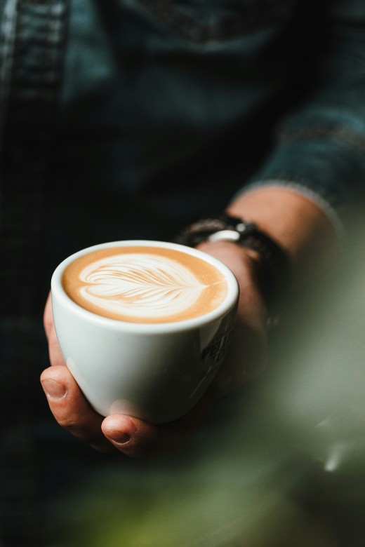 Person holding cup of cappuccino, photo by BENCE BOROS on Unsplash