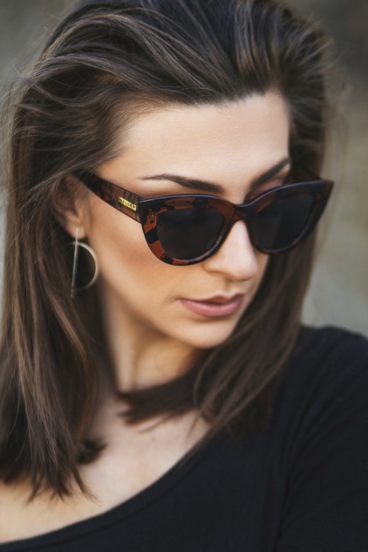 Woman in black sunglasses and black shirt, photo by Apostolos Vamvouras on Unsplash