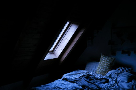 Bed and window at night, photo by Christopher Farrugia on Unsplash