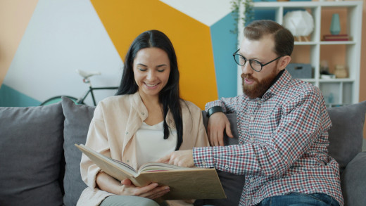 Couple looking at a book together Couple looking at a book together