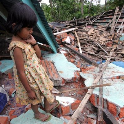 An Indonesian girl on her ruined house.