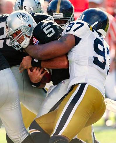 Oakland Raiders quarterback Bruce Gradkowski (5) is brought down by New York Jets linebacker Calvin Pace in the third quarter of an NFL football game in Oakland, Calif., Sunday, Oct. 25, 2009. (AP Photo/Ben Margot)