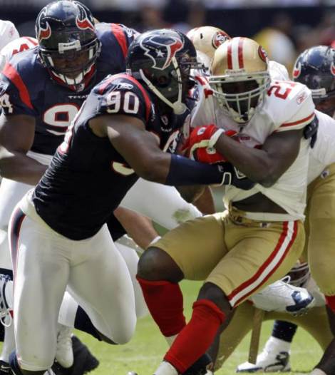 San Francisco 49ers running back Frank Gore (21) is tackled for a loss by Houston Texans defensive end Mario Williams (90) during the second quarter of a NFL football game Sunday, Oct. 25, 2009 in Houston. (AP Photo/David J. Phillip)