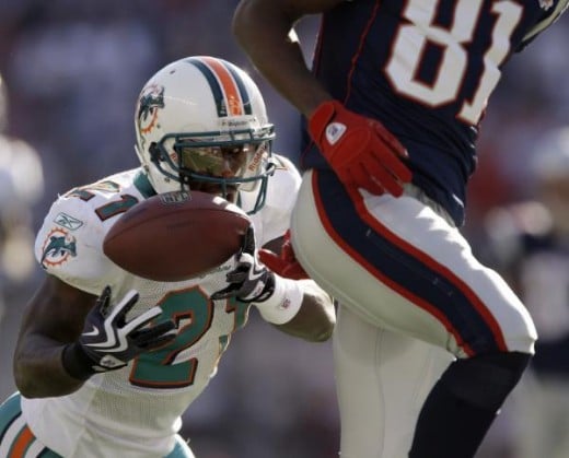 Miami Dolphins cornerback Vontae Davis (21) makes an interception behind New England Patriots wide receiver Randy Moss (81) during the first quarter of their NFL football game in Foxborough, Mass., Sunday, Nov. 8, 2009. (AP Photo/Charles Krupa)