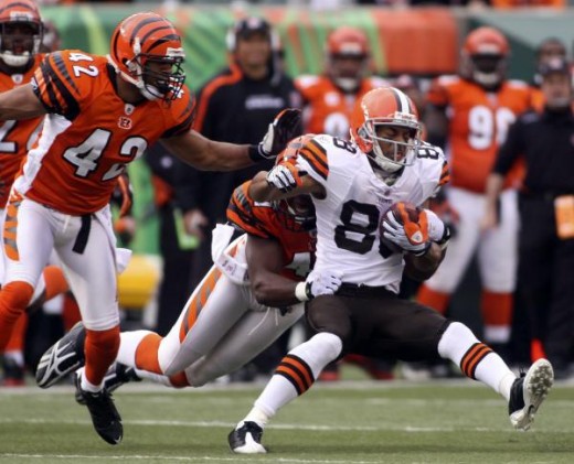 Cleveland Browns wide receiver Chansi Stuckey, right, is dragged down by Cincinnati Bengals' Chinedum Ndukwe as Ndukwe's teammate Chris Crocker (42) looks on during the first half of their NFL football game in Cincinnati, Sunday, Nov. 29, 2009. (AP P