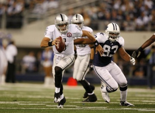 Bruce Gradkowski (5) runs away from Dallas Cowboys linebacker Anthony Spencer (93) in an NFL football game, Thursday, Nov. 26, 2009 in Arlington, Texas. (AP Photo/Mike Stone)