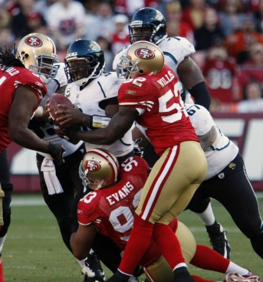David Garrard, center, is brought down by San Francisco 49ers' Ray McDonald, top left, Demetric Evans, bottom, and Patrick Willis, top right, during the third quarter of an NFL football game in San Francisco, Sunday, Nov. 29, 2009. (AP Photo/Paul Sak