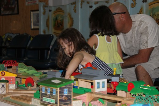 room full of train tables for kids - big and small - to play with