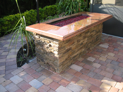 Custom built fire pit uses crushed fire glass.