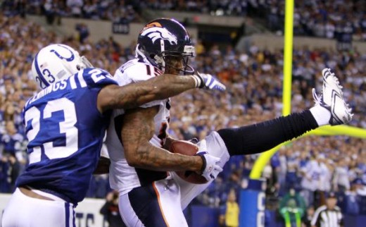 Denver Broncos wide receiver Brandon Marshall makes a 5-yard touchdown reception while being defended by Indianapolis Colts safety Tim Jennings during the fourth quarter of an NFL football game in Indianapolis, Sunday, Dec. 13, 2009. Indianapolis won