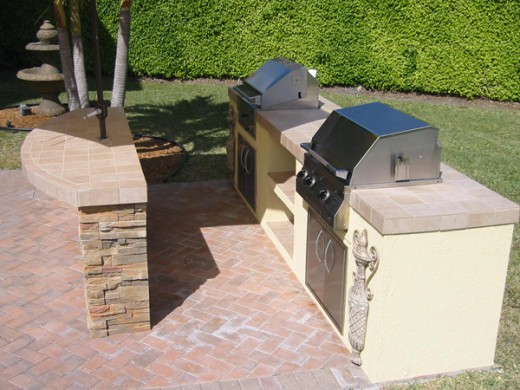 stainless steel charcoal bbq and gas grill built into outdoor kitchen