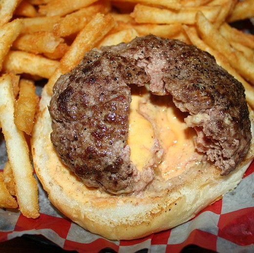 The Juicy Lucy is a piece of cheddar cheese surrounded by raw hamburger meat and then the hamburger is cooked resulting in a molten core of cheddar cheese and a tasty treat with every bite. 