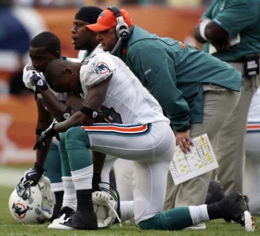 Miami Dolphins players and staff look on as quarterback Pat White (not shown) is attended to and then carted off the field with a head injury following a helmet-to-helmet collision with Pittsburgh Steelers cornerback IkeTaylor. (AP Photo/J Pat Carter